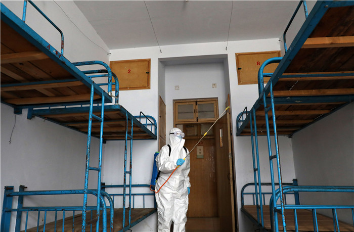 4月7日,在博兴县第一中学,一名工作人员在高三学生宿舍喷洒消毒液.